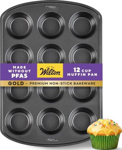 Wilton gold-colored 12-cup non-stick muffin pan viewed from above, with standard-size round wells and extended handles on each end