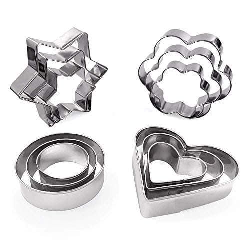 Twelve stainless steel cookie cutters grouped in star, flower, round, and heart shapes across three sizes each