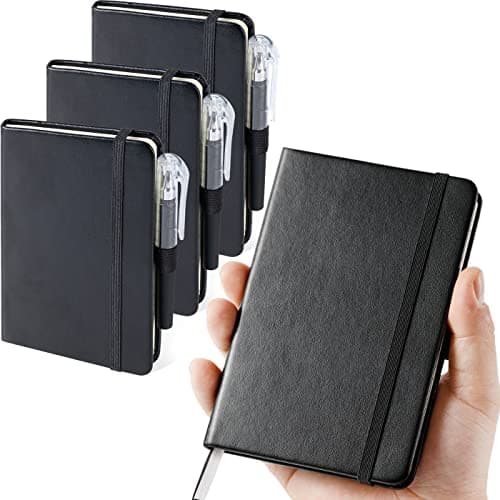 Three black faux-leather A6 pocket notebooks with matching pens fanned out, hardcover with lined pages