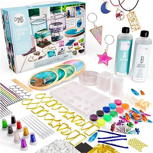 Epoxy resin craft kit with silicone pendant molds, resin dye bottles, dried flowers, decorative charms, and UV curing lamp on white background